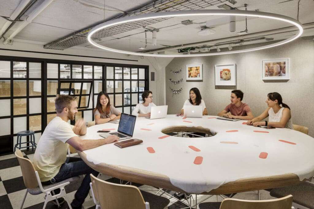 employees sit around a desk